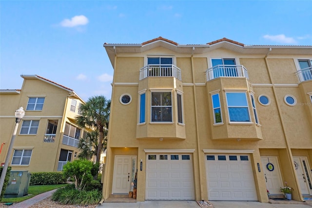 view of property with a balcony and a garage