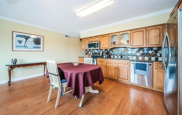 kitchen with backsplash, stainless steel appliances, sink, and a textured ceiling