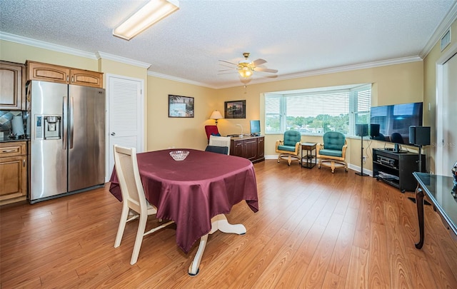 dining area with ornamental molding, ceiling fan, a textured ceiling, and light hardwood / wood-style flooring