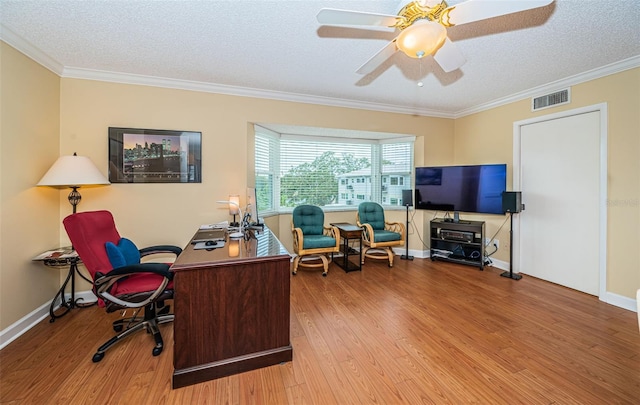 office space with ceiling fan, light hardwood / wood-style flooring, ornamental molding, and a textured ceiling