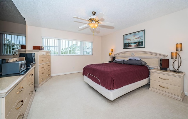 bedroom with light carpet, a textured ceiling, and ceiling fan