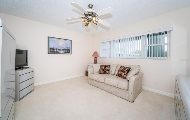 carpeted living room with ceiling fan and a textured ceiling