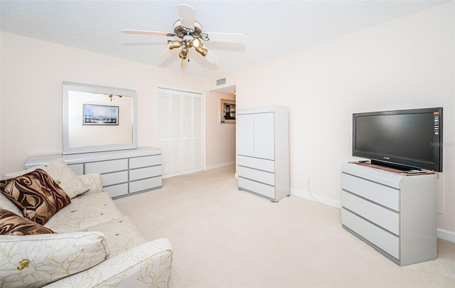 carpeted living room with ceiling fan and a textured ceiling