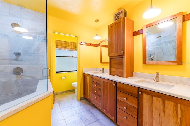 bathroom with vanity, toilet, tile patterned floors, and a shower with door