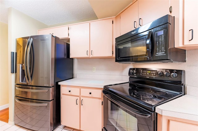 kitchen featuring black appliances, a textured ceiling, and light hardwood / wood-style floors