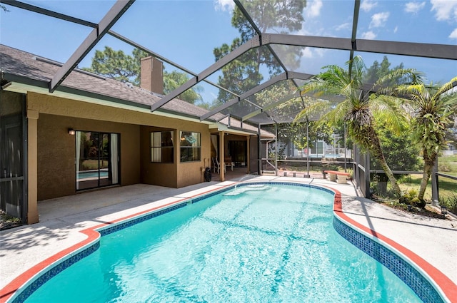 view of pool with a patio and glass enclosure