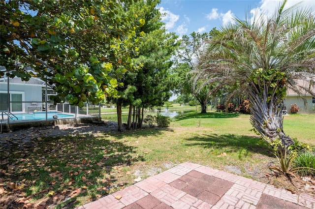 view of yard with a water view, a patio area, and a lanai