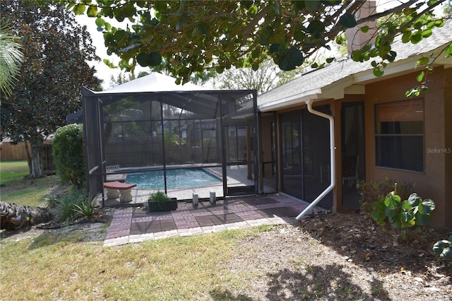 view of swimming pool featuring a patio, glass enclosure, and a yard