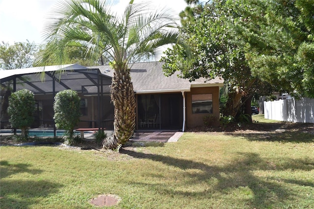 view of front of home featuring a front yard and glass enclosure