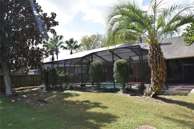 view of yard with a fenced in pool and glass enclosure