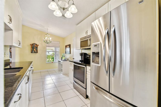 kitchen with pendant lighting, white cabinetry, stainless steel appliances, dark stone countertops, and a chandelier