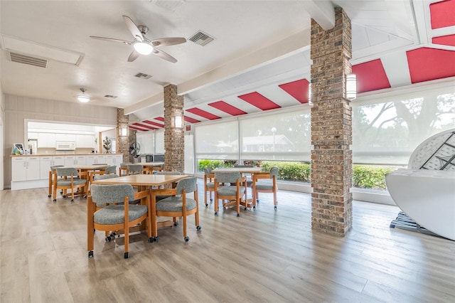 dining space featuring ceiling fan, light hardwood / wood-style floors, and ornate columns