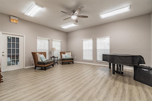 sitting room featuring ceiling fan, a textured ceiling, and light hardwood / wood-style flooring