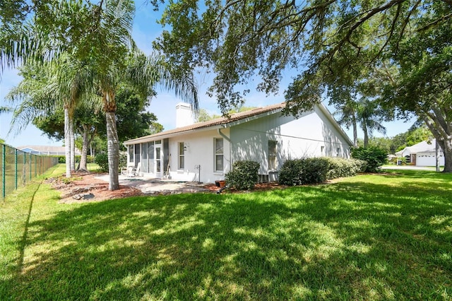 rear view of house featuring a yard and a patio