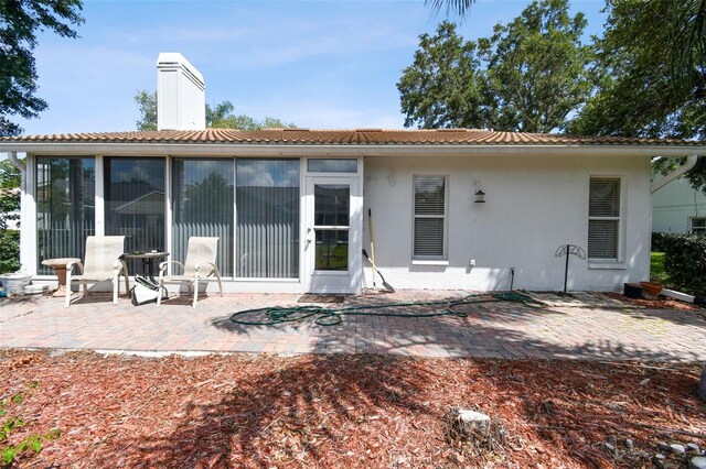 back of house with a sunroom and a patio