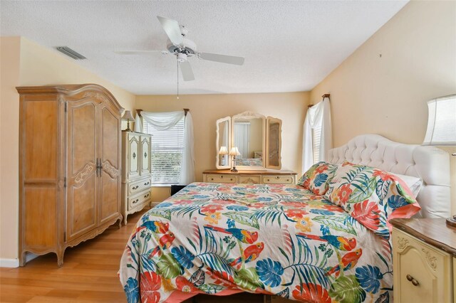 bedroom featuring a textured ceiling, ceiling fan, and light hardwood / wood-style flooring