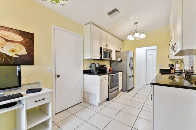 kitchen featuring sink, an inviting chandelier, hanging light fixtures, stainless steel appliances, and white cabinets