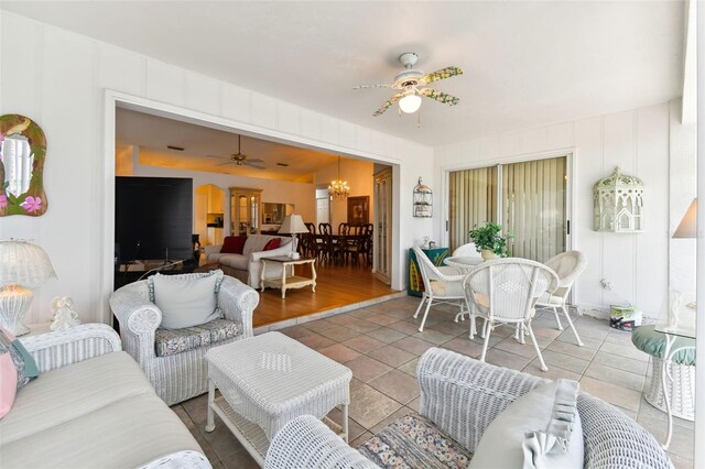 living room featuring tile patterned floors and ceiling fan with notable chandelier