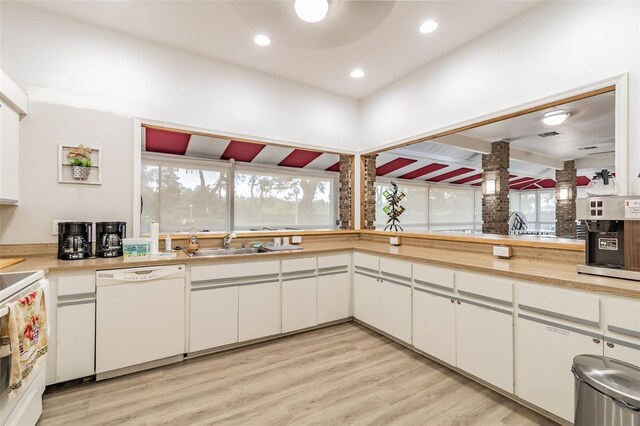 kitchen with white cabinetry, sink, white appliances, and light wood-type flooring