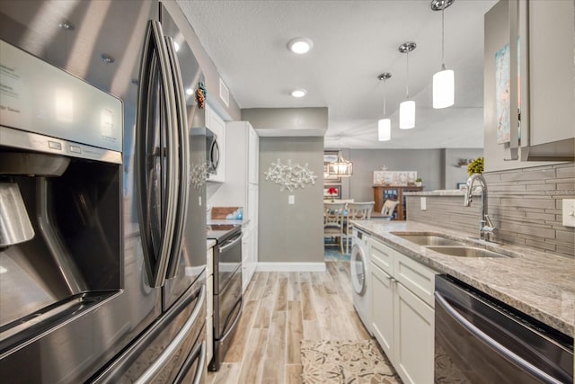 kitchen featuring decorative light fixtures, appliances with stainless steel finishes, light hardwood / wood-style flooring, tasteful backsplash, and white cabinets