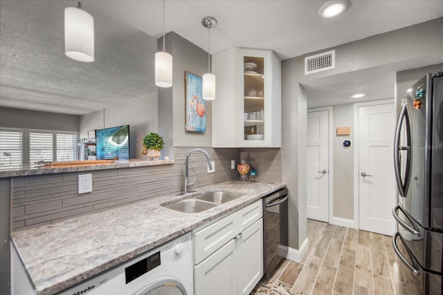 kitchen featuring white cabinetry, backsplash, appliances with stainless steel finishes, sink, and a textured ceiling