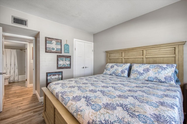 bedroom featuring wood-type flooring and a textured ceiling