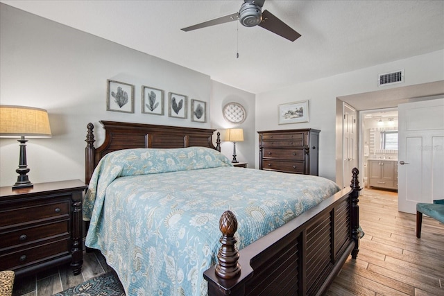 bedroom with ensuite bath, hardwood / wood-style floors, and ceiling fan