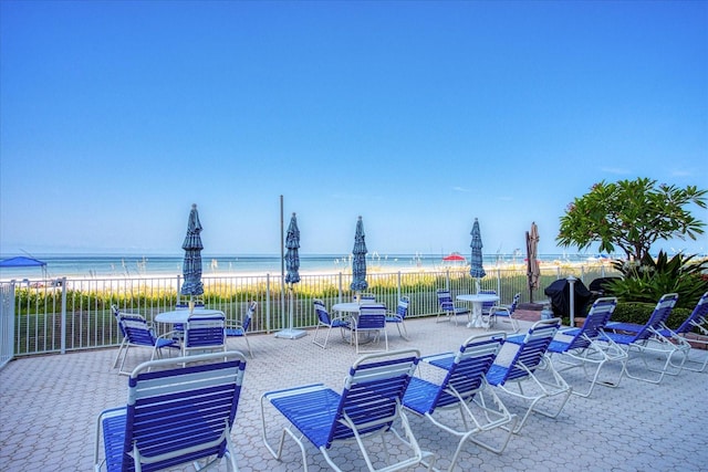 view of patio / terrace featuring a water view and a view of the beach