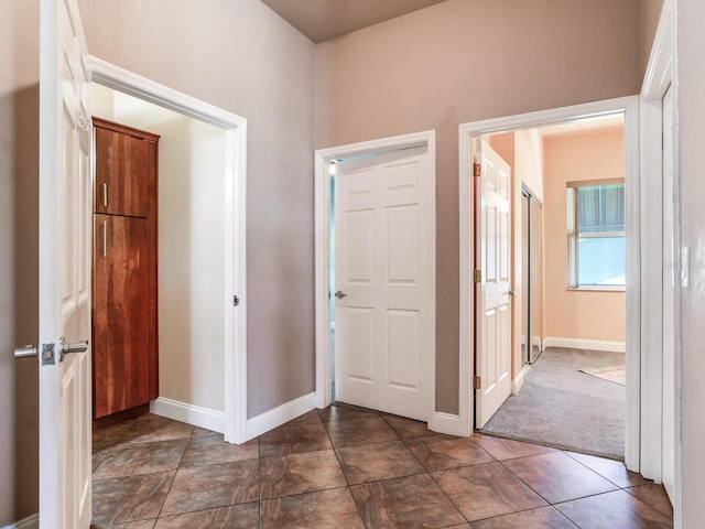 hallway featuring dark carpet