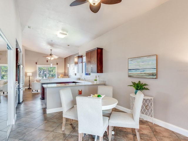 dining space with ceiling fan, sink, and vaulted ceiling