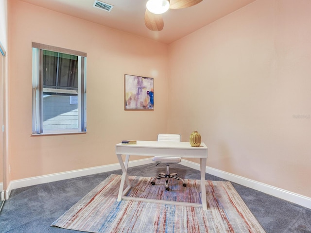 unfurnished office with ceiling fan and dark carpet