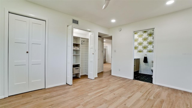 unfurnished bedroom with a closet, light hardwood / wood-style floors, and ensuite bathroom