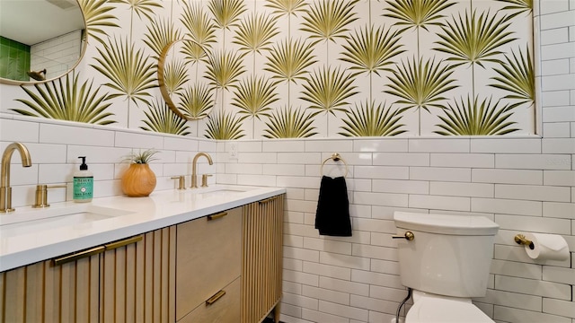 bathroom featuring vanity, toilet, and tile walls