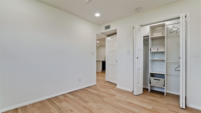 unfurnished bedroom with a closet and light wood-type flooring