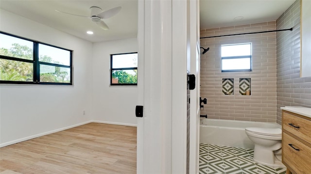 full bathroom with tile flooring, ceiling fan, tiled shower / bath combo, toilet, and vanity