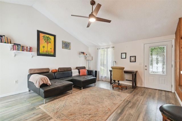 living room featuring vaulted ceiling, a healthy amount of sunlight, and hardwood / wood-style flooring