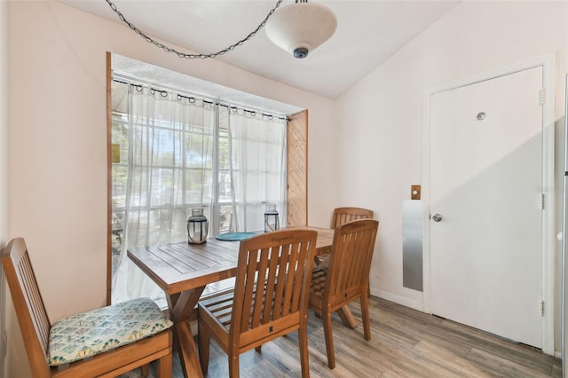 dining area featuring hardwood / wood-style flooring and lofted ceiling