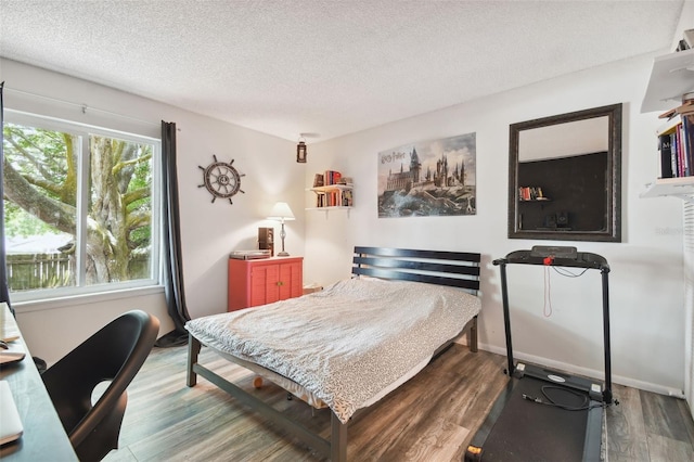 bedroom with hardwood / wood-style floors and a textured ceiling