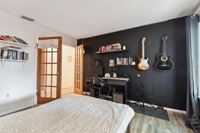 bedroom featuring wood-type flooring and a textured ceiling