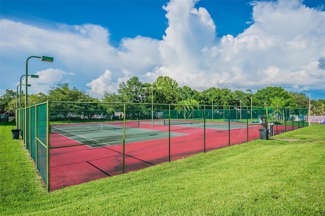 view of sport court with a lawn