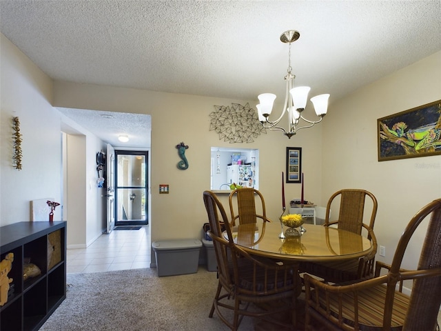 tiled dining room featuring a notable chandelier and a textured ceiling