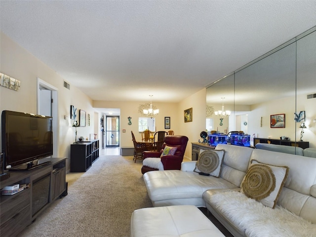 living room with a textured ceiling, carpet floors, and a notable chandelier