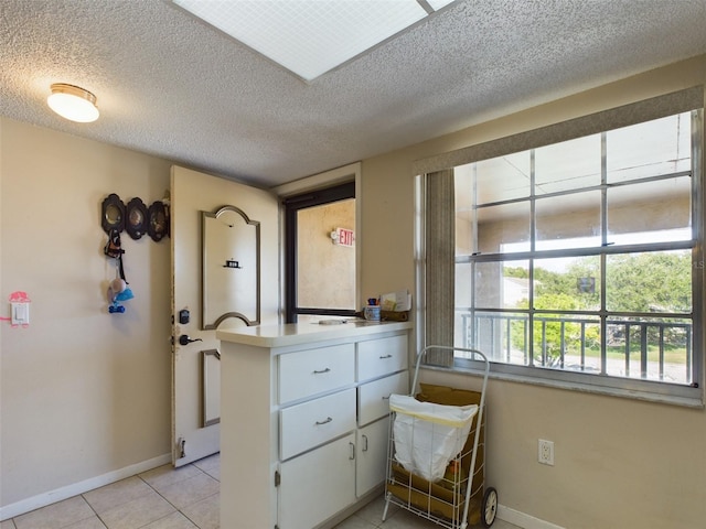 interior space with light tile flooring and a textured ceiling