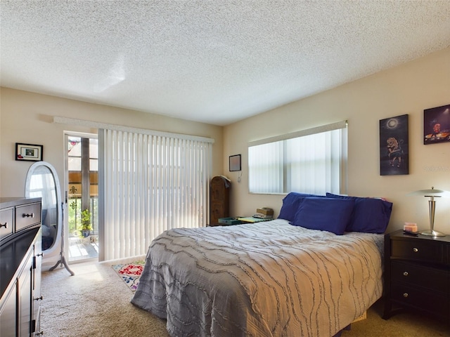 bedroom featuring light carpet, access to exterior, and a textured ceiling