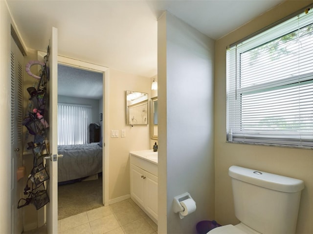 bathroom featuring tile floors, vanity, and toilet