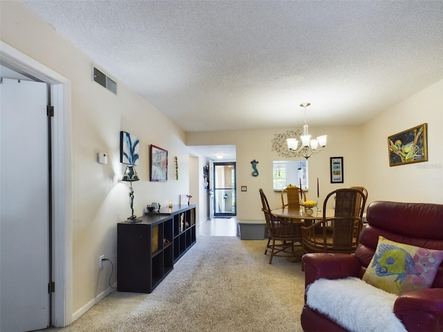 living room with a chandelier, carpet floors, and a textured ceiling