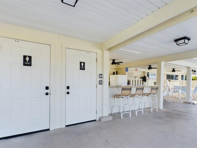 entrance to property with a patio area, an outdoor bar, and ceiling fan