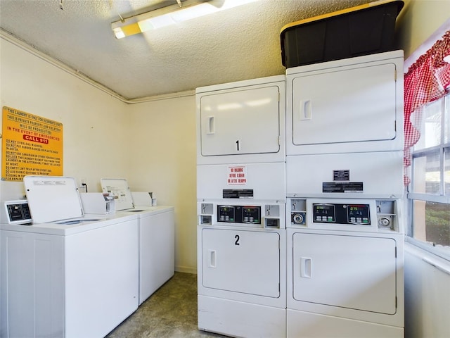 clothes washing area with stacked washer and clothes dryer, plenty of natural light, separate washer and dryer, and a textured ceiling