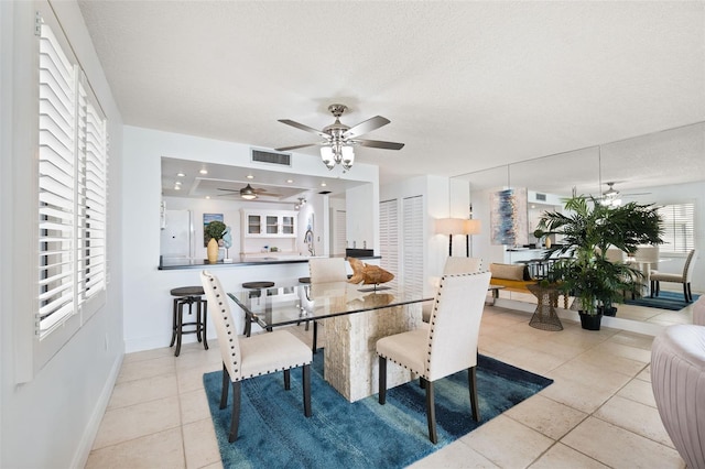 tiled dining area with a textured ceiling and sink