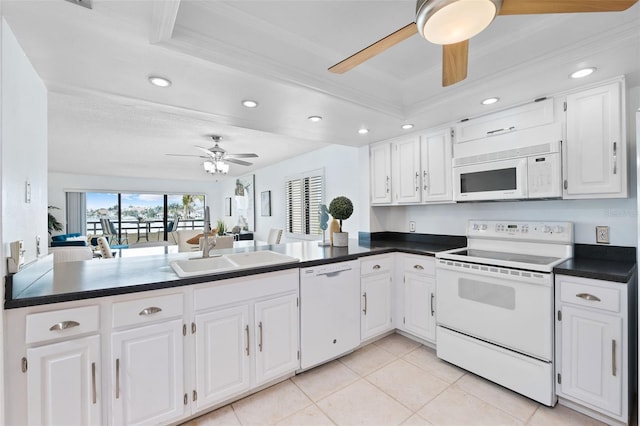 kitchen with white appliances, kitchen peninsula, white cabinetry, and sink